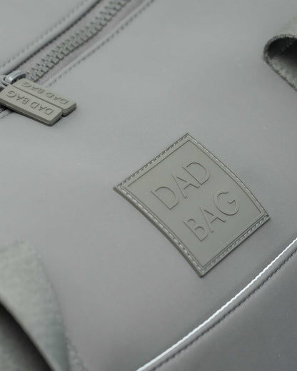 Light gray duffel and hospital bag with 'DAD BAG' label on a neutral background