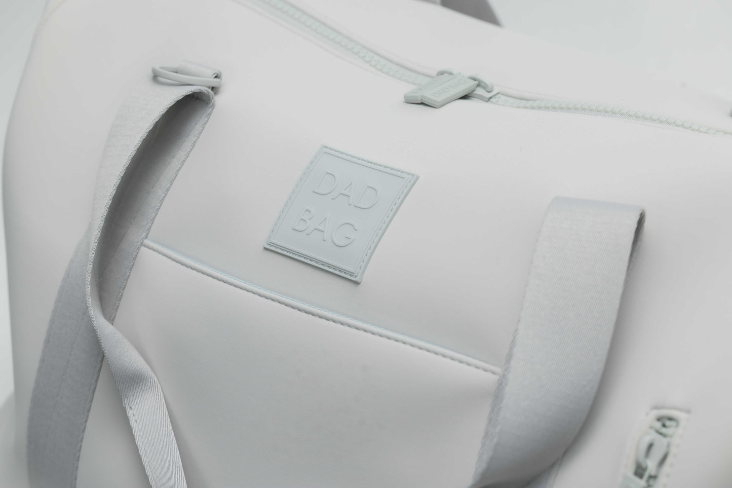 Light gray neoprene bag with a visible dad bag brand label on a light gray background