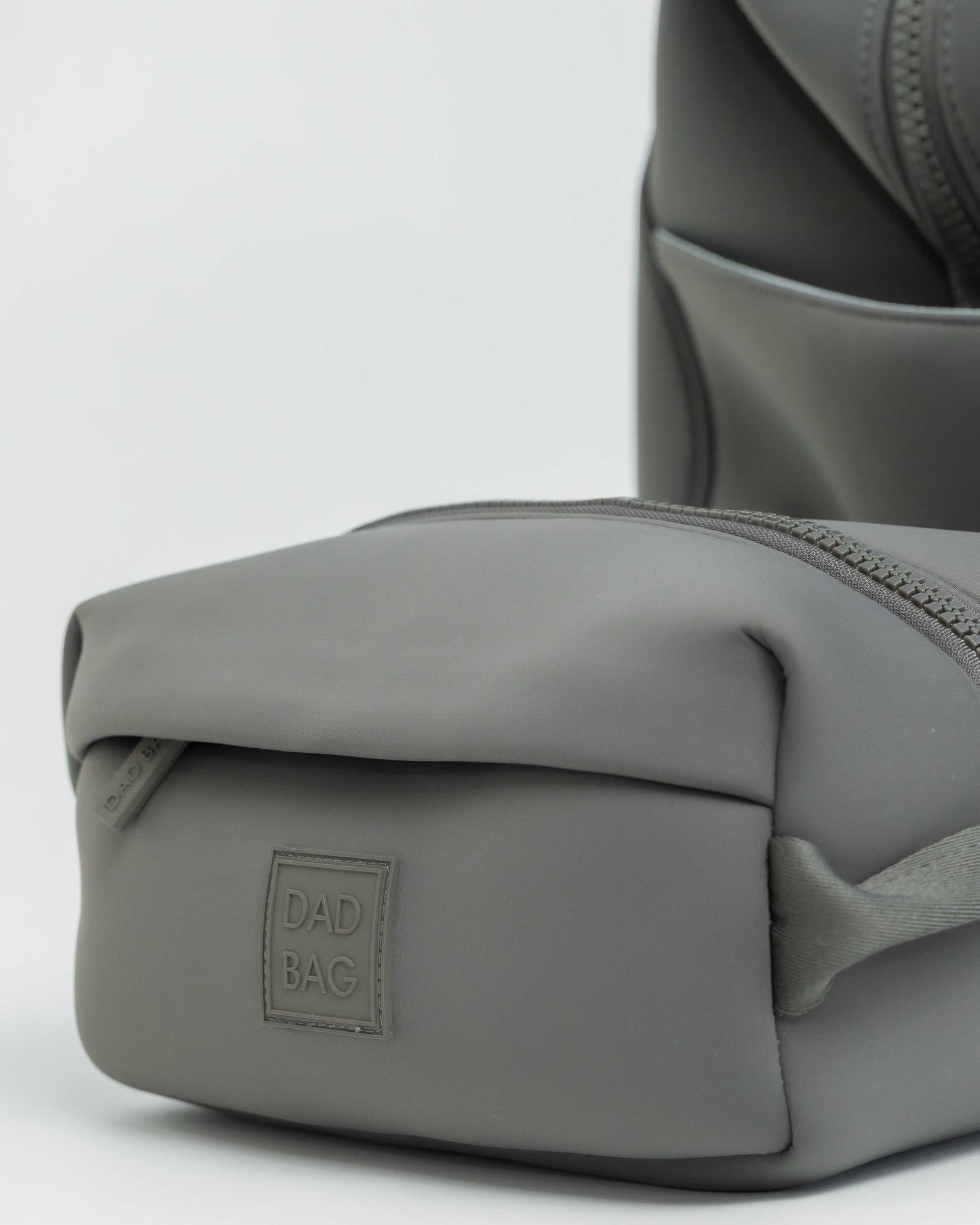 Gray neoprene hospital duffel bag with a toiletry bag on a light gray background
