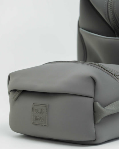 Gray neoprene hospital duffel bag with a toiletry bag on a light gray background